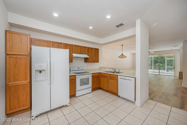 401 Trotter Ln Unit 103, Melbourne, FL 32940 - kitchen featuring white appliances, under cabinet range hood, a sink, light countertops, and light tile patterned floors