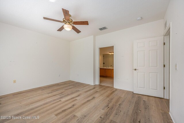 401 Trotter Ln Unit 103, Melbourne, FL 32940 - unfurnished bedroom with light wood finished floors, connected bathroom, a ceiling fan, and baseboards