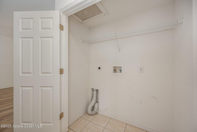 401 Trotter Ln Unit 103, Melbourne, FL 32940 - laundry room with electric dryer hookup, washer hookup, light tile patterned flooring, and baseboards