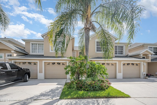 401 Trotter Ln Unit 103, Melbourne, FL 32940 - view of front of house featuring stucco siding, a garage, and driveway