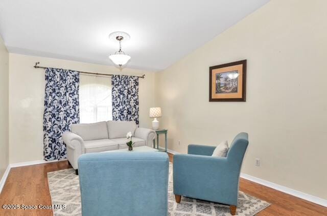 1066 Pennsylvania Ave NE, Palm Bay, FL 32907 - living area featuring wood finished floors, baseboards, and lofted ceiling