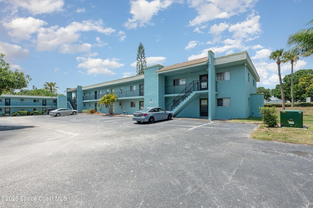 1001 W Eau Gallie Blvd Unit 205, Melbourne, FL 32935 - view of building exterior featuring uncovered parking and stairs