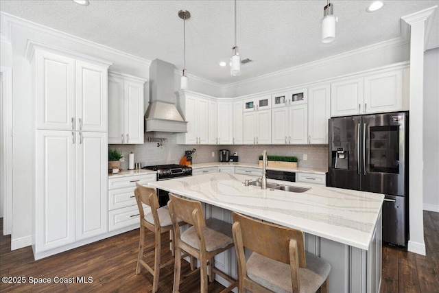 420 Rio Villa Blvd, Indialantic, FL 32903 - kitchen featuring custom range hood, stainless steel refrigerator with ice dispenser, a sink, tasteful backsplash, and dark wood-type flooring