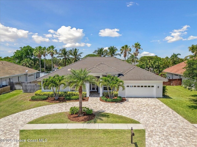 420 Rio Villa Blvd, Indialantic, FL 32903 - ranch-style house featuring curved driveway, an attached garage, a tile roof, and stucco siding