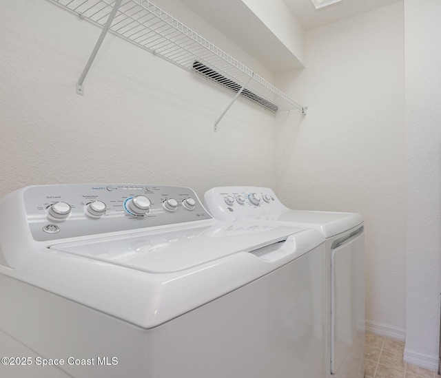 115 Turpial Way Unit 104, Melbourne, FL 32901 - washroom with independent washer and dryer, light tile patterned floors, and baseboards