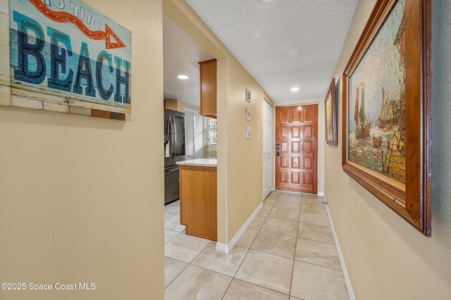 4100 Ocean Beach Blvd Unit 412, Cocoa Beach, FL 32931 - hall with a textured ceiling, light tile patterned flooring, recessed lighting, and baseboards