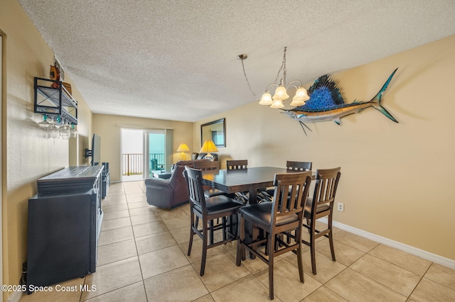 4100 Ocean Beach Blvd Unit 412, Cocoa Beach, FL 32931 - dining room with a textured ceiling, light tile patterned floors, a chandelier, and baseboards