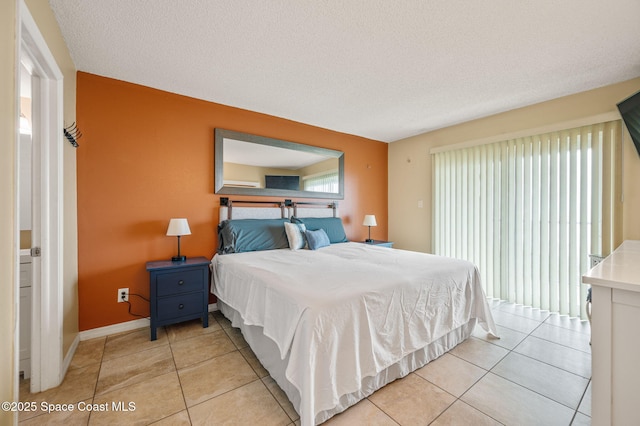4100 Ocean Beach Blvd Unit 412, Cocoa Beach, FL 32931 - bedroom with light tile patterned floors, baseboards, and a textured ceiling