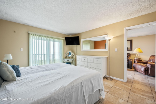 4100 Ocean Beach Blvd Unit 412, Cocoa Beach, FL 32931 - bedroom with a textured ceiling, light tile patterned floors, and baseboards