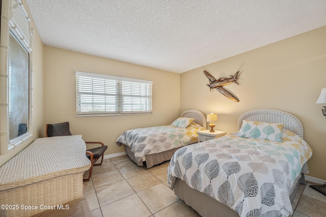 4100 Ocean Beach Blvd Unit 412, Cocoa Beach, FL 32931 - bedroom with light tile patterned floors, a textured ceiling, and baseboards