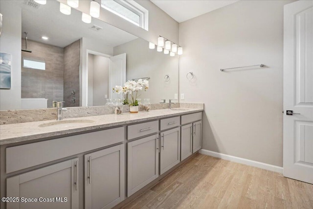 2377 Aquilos Ave SE Unit 46, Palm Bay, FL 32909 - full bathroom featuring double vanity, tiled shower, wood finished floors, baseboards, and plenty of natural light