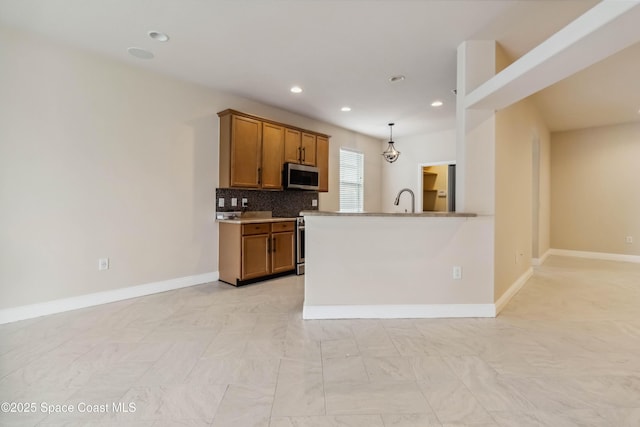2262 Lune Ct, West Melbourne, FL 32904 - kitchen with stainless steel appliances, brown cabinets, recessed lighting, baseboards, and tasteful backsplash