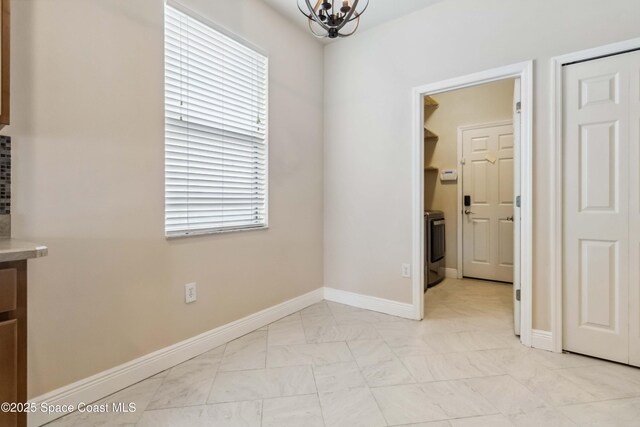 2262 Lune Ct, West Melbourne, FL 32904 - unfurnished dining area with a chandelier, washer / dryer, and baseboards