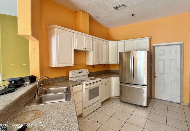 4155 Devoe Ave, Cocoa, FL 32927 - kitchen featuring freestanding refrigerator, electric range, a sink, a textured ceiling, and light tile patterned flooring