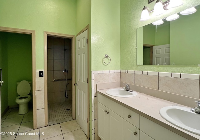 4155 Devoe Ave, Cocoa, FL 32927 - bathroom featuring toilet, double vanity, tile patterned flooring, a textured wall, and tile walls