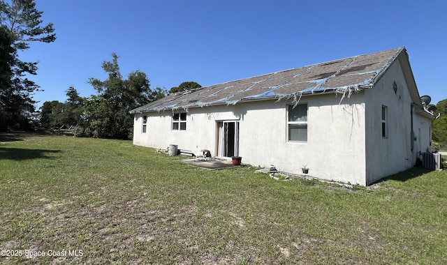4155 Devoe Ave, Cocoa, FL 32927 - back of property with cooling unit, stucco siding, a lawn, and a shingled roof