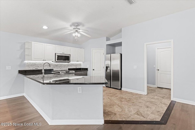 3817 Sunbeam Ct, Merritt Island, FL 32953 - kitchen featuring stainless steel appliances, open shelves, a peninsula, ceiling fan, and tasteful backsplash