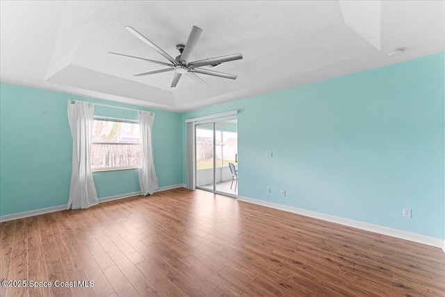 3817 Sunbeam Ct, Merritt Island, FL 32953 - unfurnished room featuring a ceiling fan, wood finished floors, baseboards, a raised ceiling, and a smoke detector