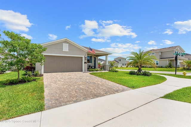 2376 Kamin Dr, Melbourne, FL 32940 - ranch-style house featuring a front lawn, decorative driveway, an attached garage, and stucco siding