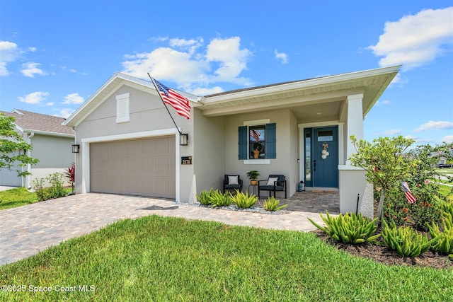 2376 Kamin Dr, Melbourne, FL 32940 - view of front of house featuring stucco siding, a garage, decorative driveway, a porch, and a front yard
