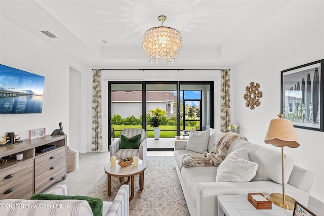 2376 Kamin Dr, Melbourne, FL 32940 - living room featuring a chandelier, light tile patterned flooring, and a raised ceiling