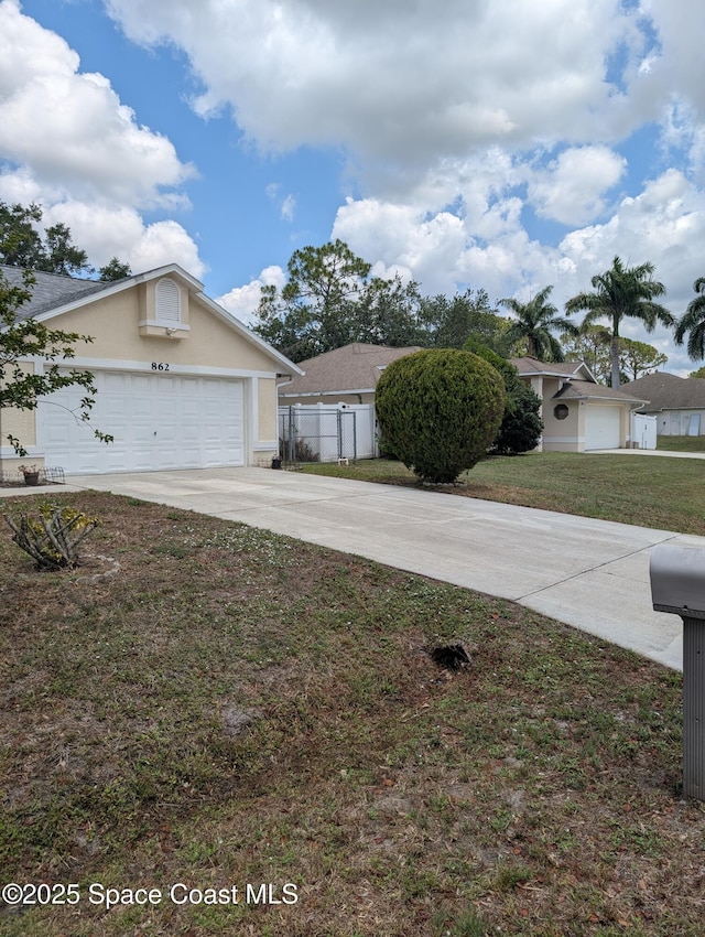 862 Aachen Ave NW, Palm Bay, FL 32907 - view of front of property featuring concrete driveway, stucco siding, and an attached garage