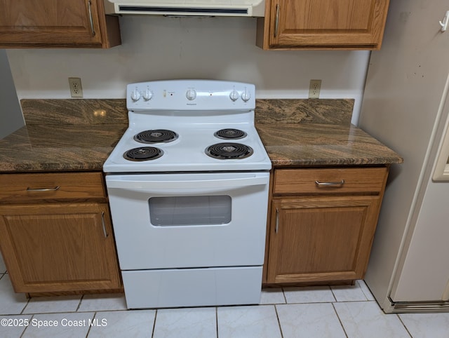 862 Aachen Ave NW, Palm Bay, FL 32907 - kitchen with white appliances, range hood, brown cabinets, light tile patterned flooring, and dark stone counters