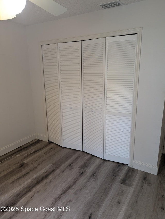 862 Aachen Ave NW, Palm Bay, FL 32907 - unfurnished bedroom with a closet, wood finished floors, and baseboards