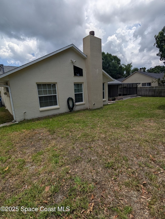862 Aachen Ave NW, Palm Bay, FL 32907 - back of property featuring a chimney, stucco siding, and a sunroom