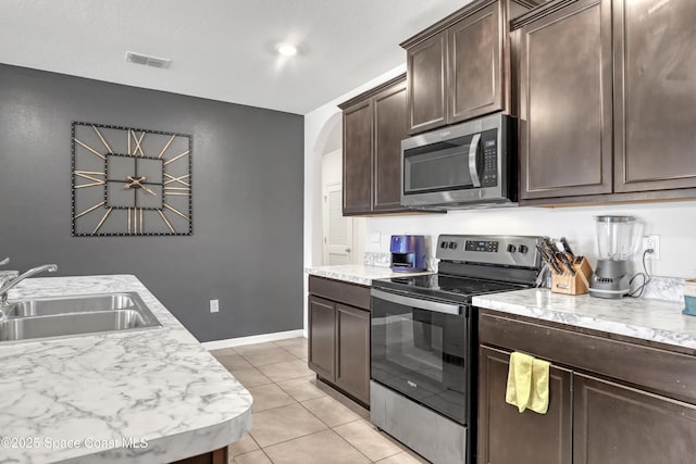 1005 Slocum St NW, Palm Bay, FL 32907 - kitchen featuring stainless steel appliances, a sink, light countertops, and dark brown cabinetry