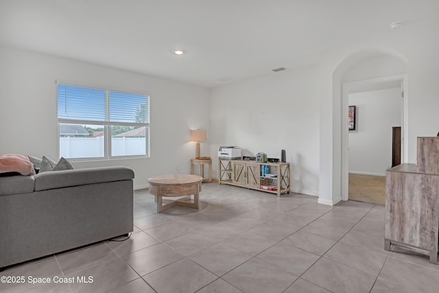 1005 Slocum St NW, Palm Bay, FL 32907 - living area featuring light tile patterned floors, arched walkways, baseboards, and recessed lighting