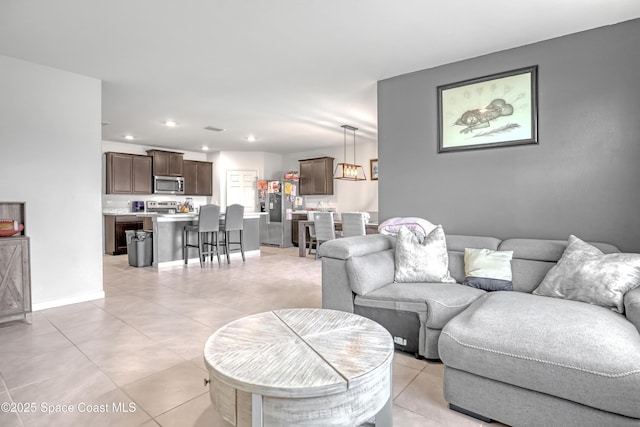 1005 Slocum St NW, Palm Bay, FL 32907 - living room with light tile patterned floors, recessed lighting, and baseboards