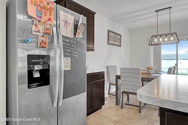 1005 Slocum St NW, Palm Bay, FL 32907 - kitchen featuring stainless steel fridge, dark brown cabinets, light tile patterned floors, and light countertops