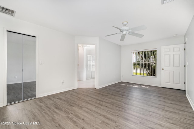 1555 Knoll Ridge Dr, Melbourne, FL 32940 - unfurnished bedroom with wood finished floors, baseboards, ensuite bathroom, a closet, and ceiling fan