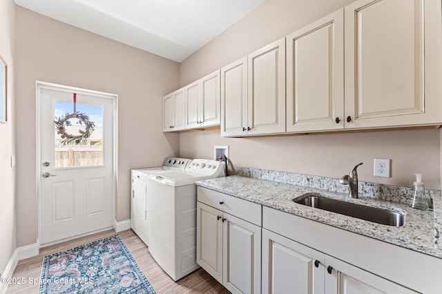 1641 Earlham Ave NW, Palm Bay, FL 32907 - laundry area featuring cabinet space, separate washer and dryer, light wood-style floors, and baseboards