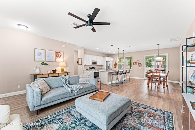 1641 Earlham Ave NW, Palm Bay, FL 32907 - living area with light wood-type flooring, a ceiling fan, and baseboards