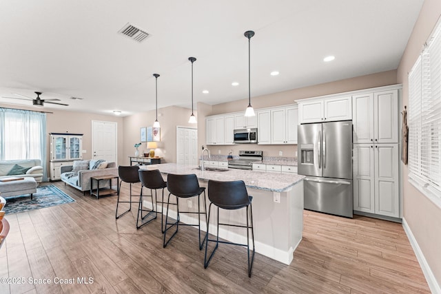 1641 Earlham Ave NW, Palm Bay, FL 32907 - kitchen with stainless steel appliances, a kitchen bar, a sink, light wood-style floors, and recessed lighting