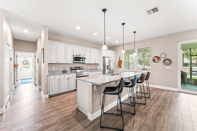 1641 Earlham Ave NW, Palm Bay, FL 32907 - kitchen featuring stainless steel appliances, a kitchen island with sink, light wood-type flooring, baseboards, and recessed lighting