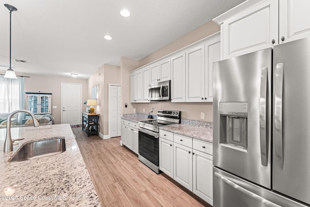 1641 Earlham Ave NW, Palm Bay, FL 32907 - kitchen with appliances with stainless steel finishes, a sink, white cabinetry, light wood-style floors, and recessed lighting