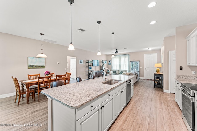 1641 Earlham Ave NW, Palm Bay, FL 32907 - kitchen with a sink, stainless steel appliances, open floor plan, baseboards, and light wood-type flooring