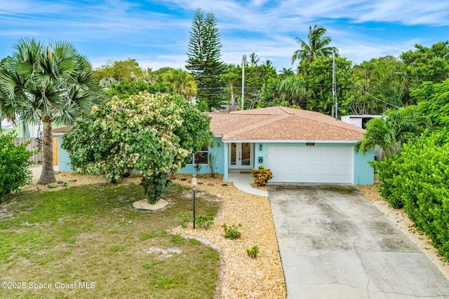475 Park Ave, Satellite Beach, FL 32937 - view of front of home featuring french doors, a garage, driveway, roof with shingles, and stucco siding