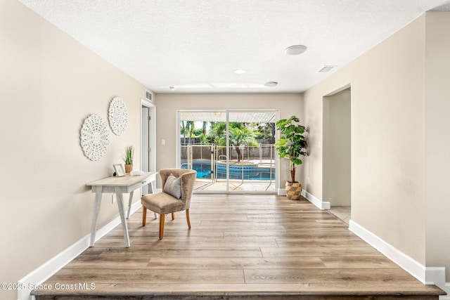 475 Park Ave, Satellite Beach, FL 32937 - sitting room featuring baseboards, wood finished floors, and a textured ceiling
