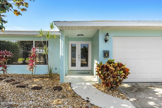 475 Park Ave, Satellite Beach, FL 32937 - view of exterior entry featuring stucco siding, an attached garage, and french doors