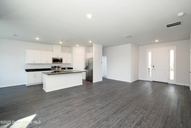 883 Parrotfish St SW, Palm Bay, FL 32908 - kitchen with appliances with stainless steel finishes, dark countertops, open floor plan, baseboards, and dark wood-type flooring