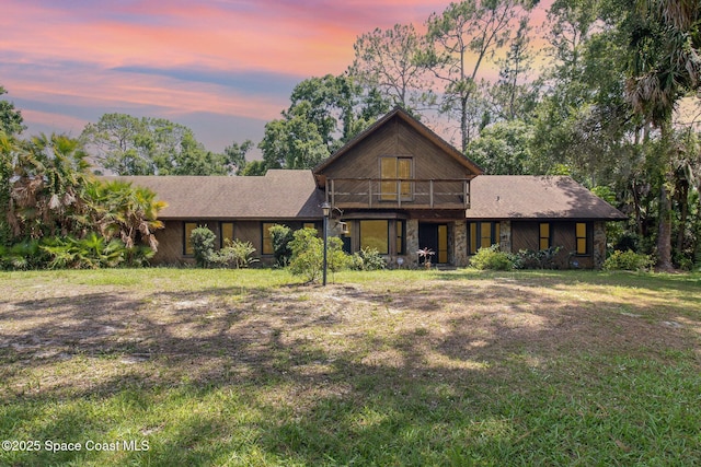 4121 Mustang Rd, Melbourne, FL 32934 - view of front of property featuring stone siding, a lawn, and a balcony