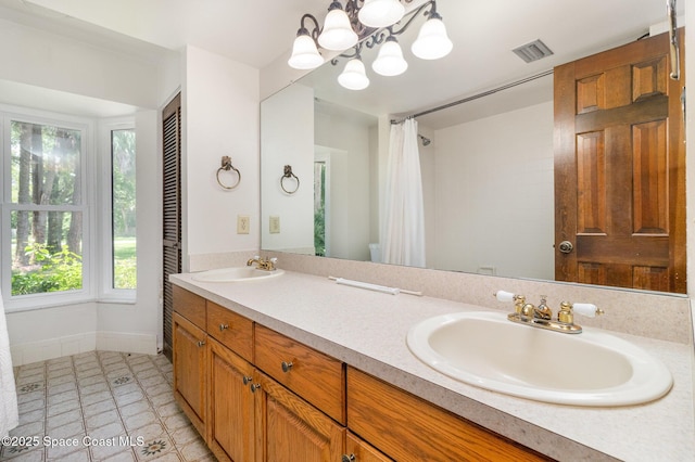4121 Mustang Rd, Melbourne, FL 32934 - bathroom featuring double vanity, baseboards, a chandelier, and a shower with shower curtain
