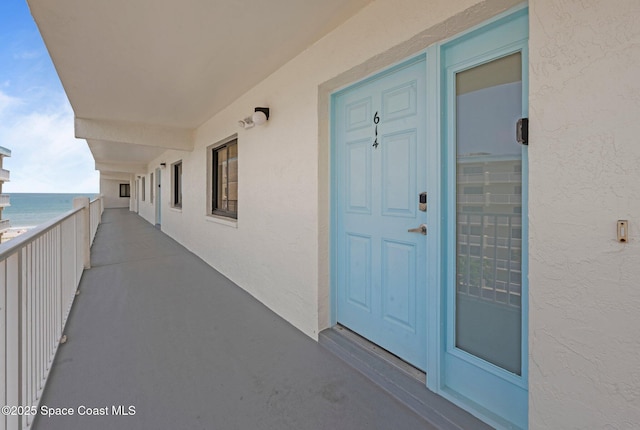 1000 N Atlantic Ave Unit 614, Cocoa Beach, FL 32931 - view of exterior entry with stucco siding, a water view, and a balcony