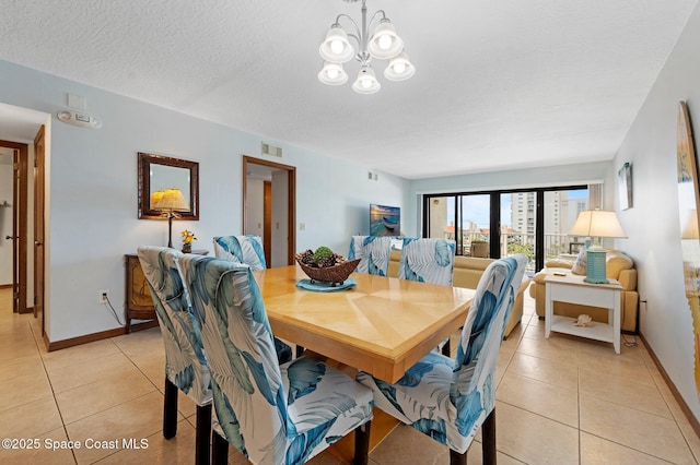 1000 N Atlantic Ave Unit 614, Cocoa Beach, FL 32931 - dining area with light tile patterned floors, baseboards, a chandelier, and a textured ceiling
