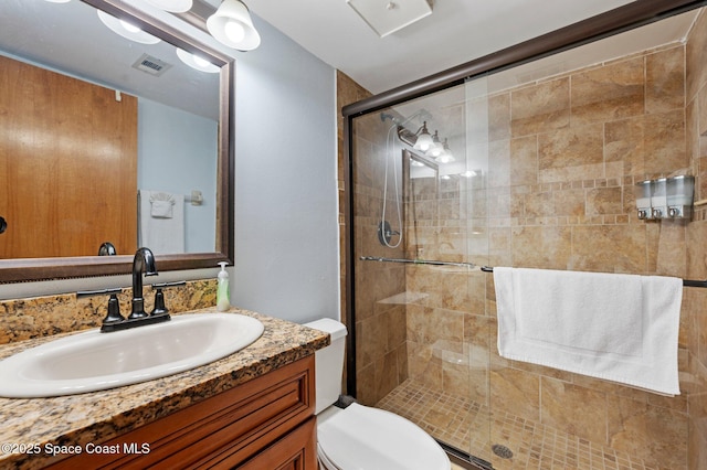 1000 N Atlantic Ave Unit 614, Cocoa Beach, FL 32931 - bathroom featuring vanity, a stall shower, and toilet