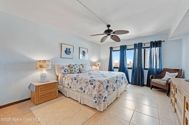 1000 N Atlantic Ave Unit 614, Cocoa Beach, FL 32931 - bedroom featuring light tile patterned floors, a textured ceiling, and ceiling fan
